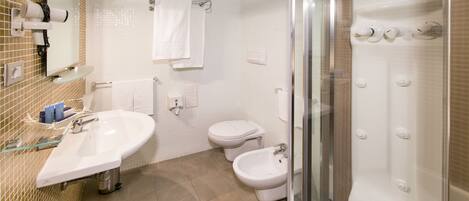 A modern bathroom with a glass-enclosed shower, a sink, a bidet, and a toilet.