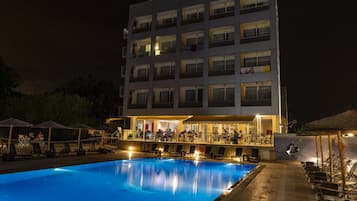 Una piscina al aire libre de temporada, sombrillas