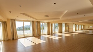 A spacious room with large windows, wooden flooring, and a ceiling with recessed lighting.