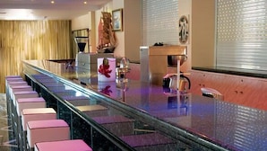 A modern bar area with a long counter and multiple bar stools.