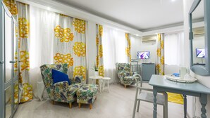 A modern living room with a sofa, armchairs, a small table, and a TV. - Relax Comfort Suites (Bucharest)
