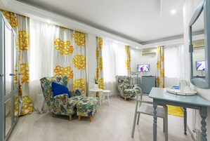 Una sala moderna con un sofá, sillones, una mesita y un televisor.