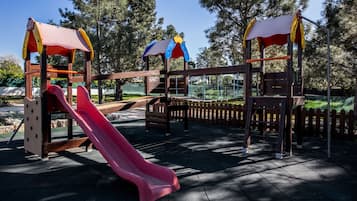 Children can play on the playground structure featuring a slide.