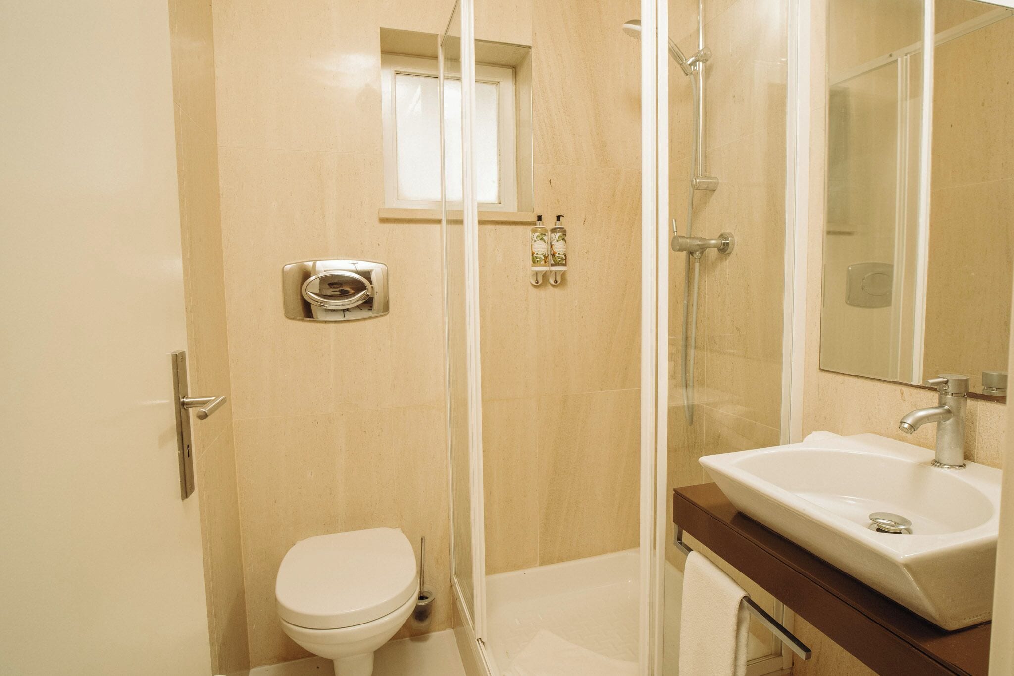 Een badkamer met toilet, douche en wastafel.