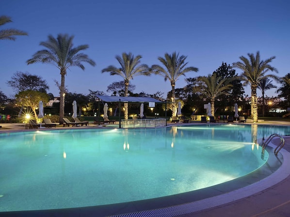 Alberca al aire libre y camastros 