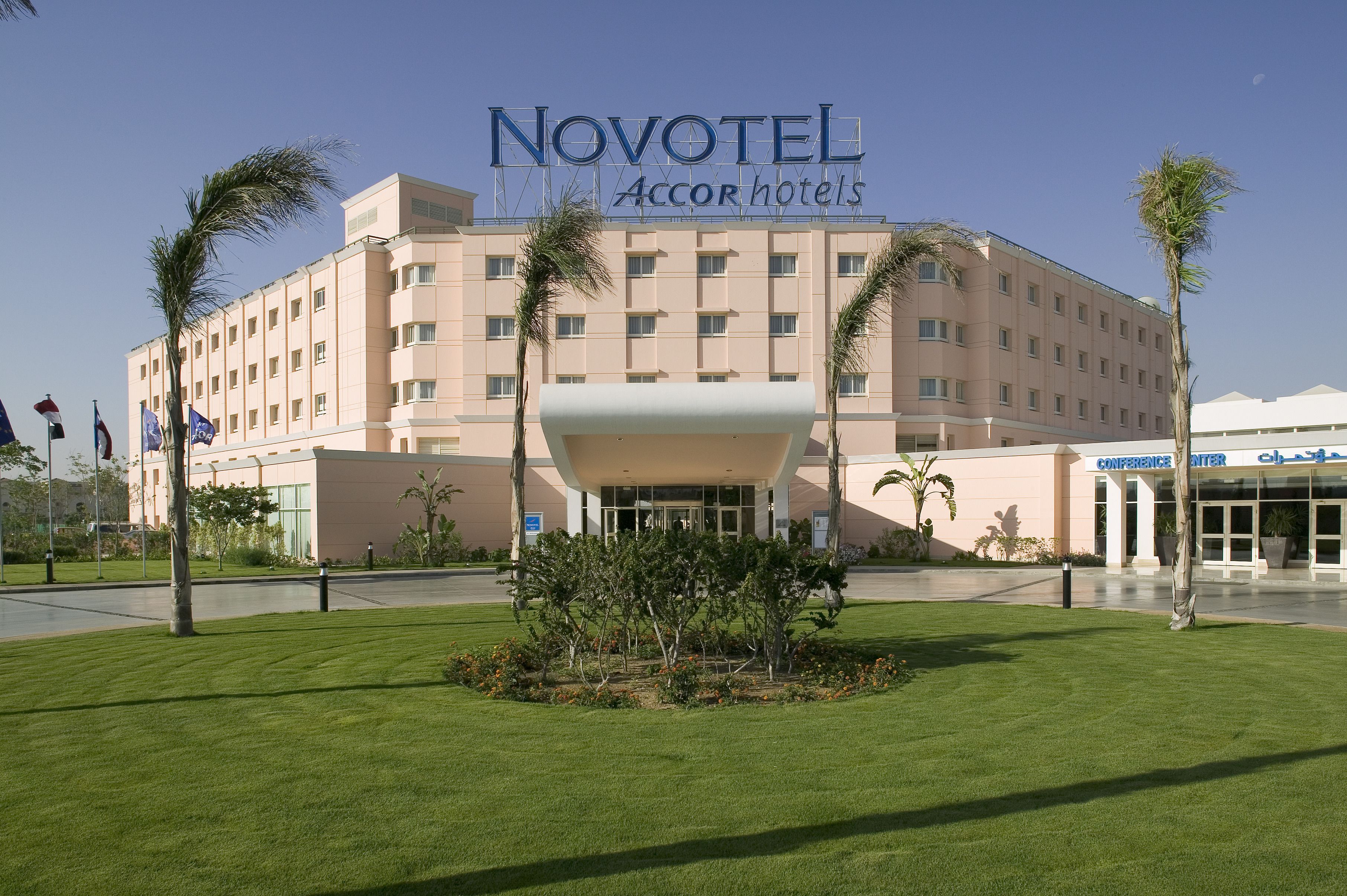 Un hôtel avec une grande enseigne indiquant « Novotel, hôtels du groupe Accor » et un centre de conférences.