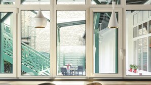 A modern interior with large windows, a staircase, and three chairs. - ibis Paris Levallois Perret (Levallois-Perret)