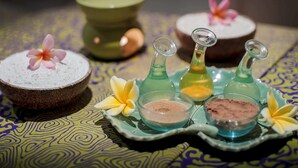 A table with various containers of powders and a green bowl, possibly for a spa or wellness setting. - TRIBE Bali Legian (Legian)