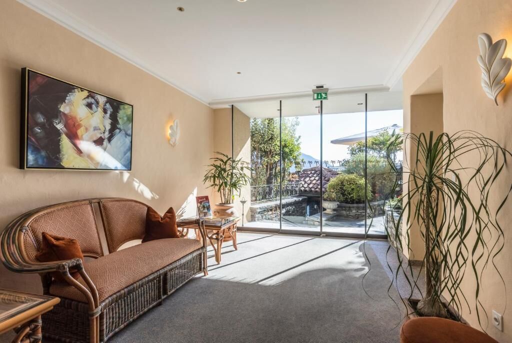 A lobby with a wicker sofa, a table with a book, and a large abstract painting on the wall.