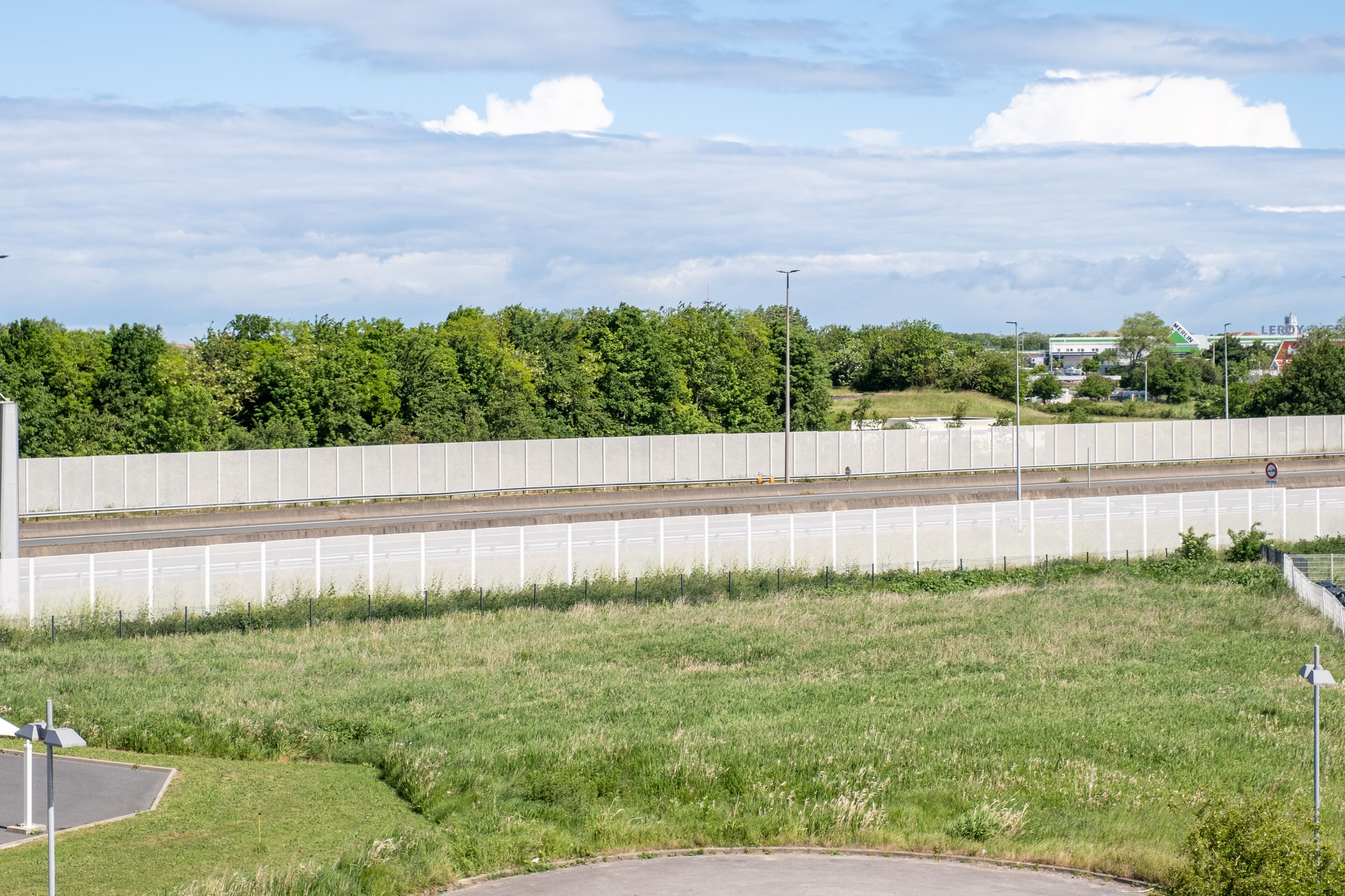 A highway with a concrete barrier and a grassy area in the foreground.