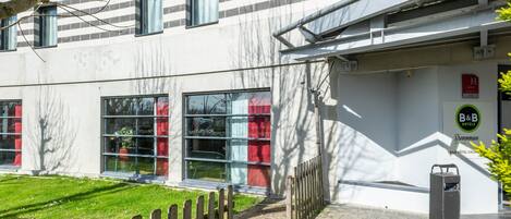 Un edificio moderno con fachada blanca, ventanas amplias y un cartel de B&B Hotels.