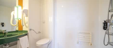 A modern bathroom with a green sink, white toilet, and a walk-in shower.