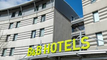 Un hôtel de type « bed and breakfast » doté d’une architecture moderne, caractérisé par une enseigne bien visible et une façade incurvée.