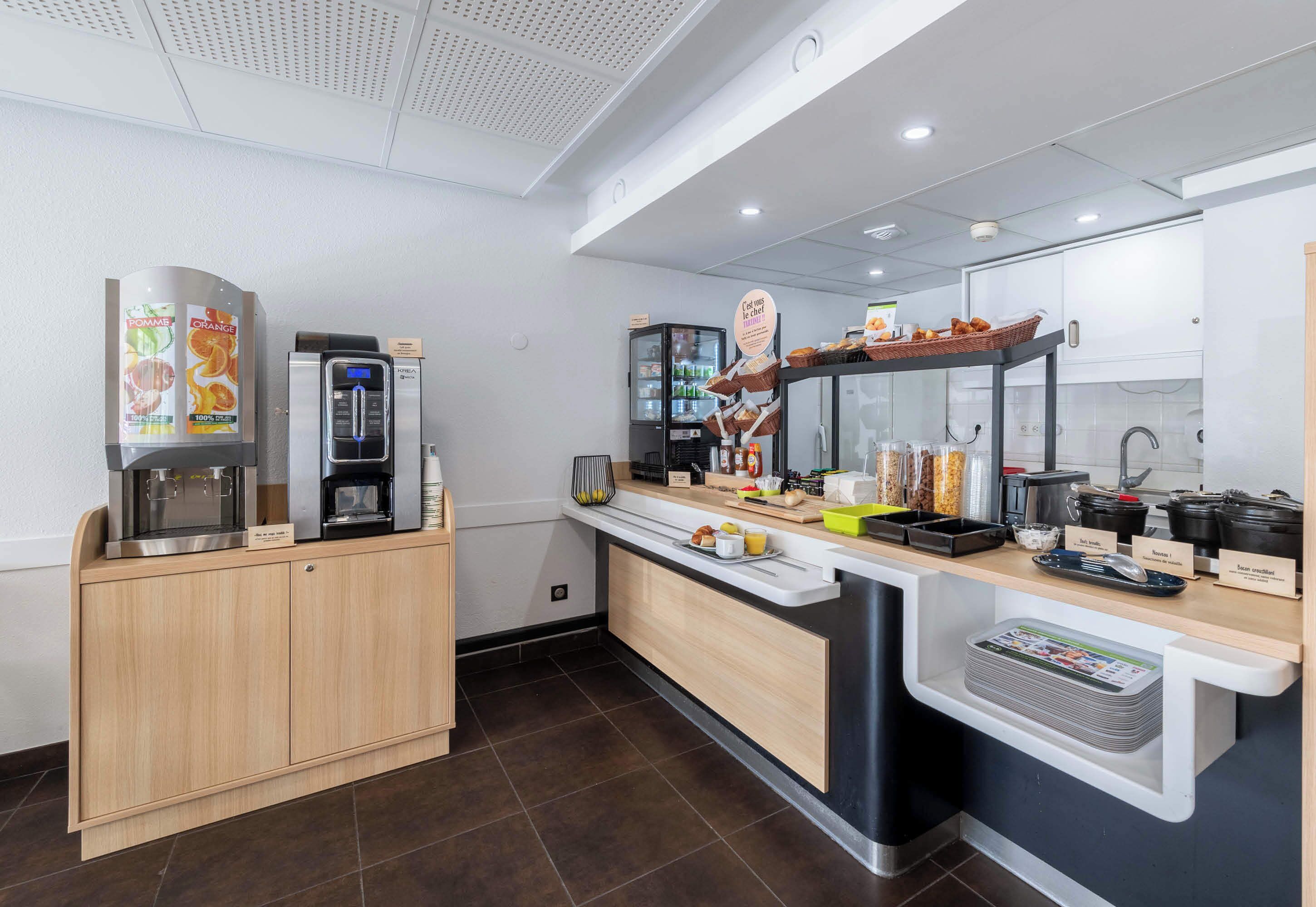 Una cocina moderna con cafetera, refrigerador y una encimera con diversos alimentos y utensilios de cocina.