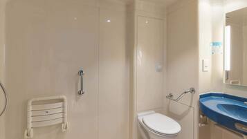 A modern bathroom with a walk-in shower, a toilet, and a sink with a mirror.