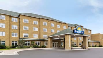 Ein Days Inn Hotel mit Backsteinfassade, zahlreichen Fenstern und einem überdachten Eingang.