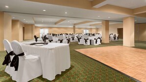 A spacious banquet hall with round tables and chairs, carpeted flooring, and a large open area. - Days Inn & Conference Centre by Wyndham Oromocto (Oromocto)