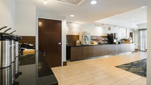 Un moderno vestíbulo de hotel con una recepción, una máquina de café y una puerta de madera.