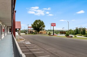 A Red Roof Inn with a parking lot and a building with a red awning.
