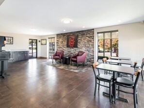 A spacious indoor area with a stone wall, seating, and a grill station. - Red Roof Inn Dandridge (Dandridge)