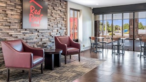 A lobby with red leather chairs, a stone wall, and a Coca-Cola sign.