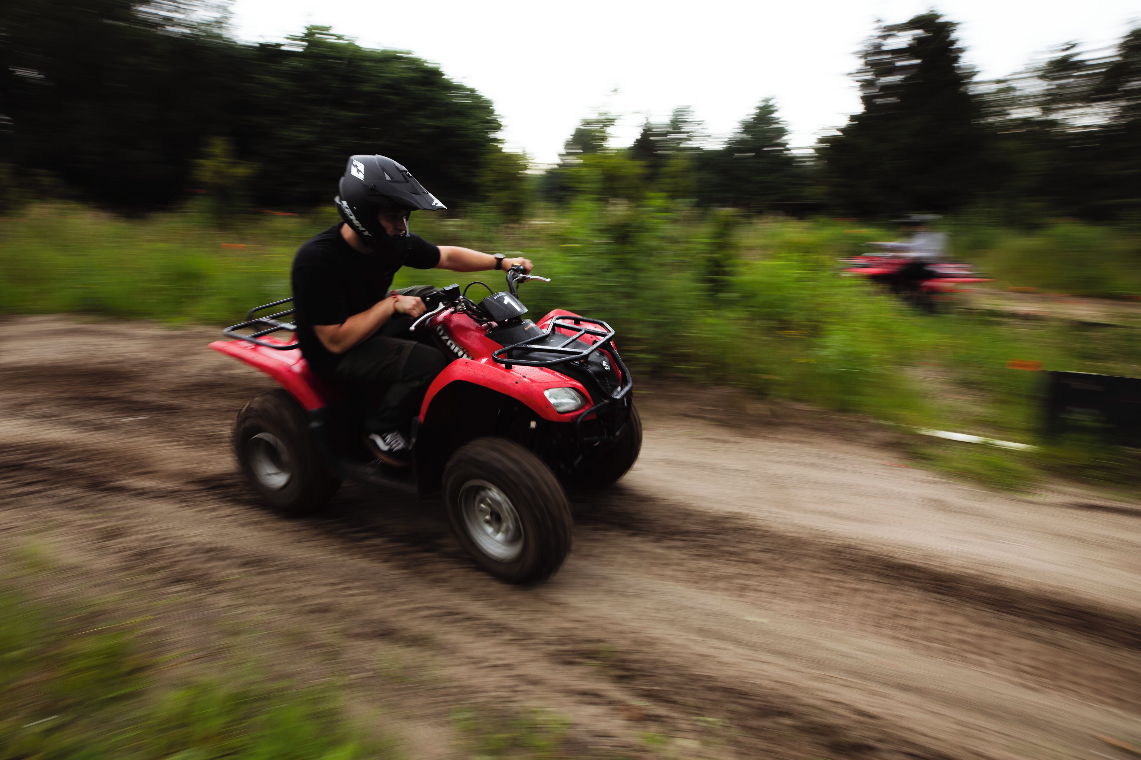 A person riding a red ATV on a dirt path.