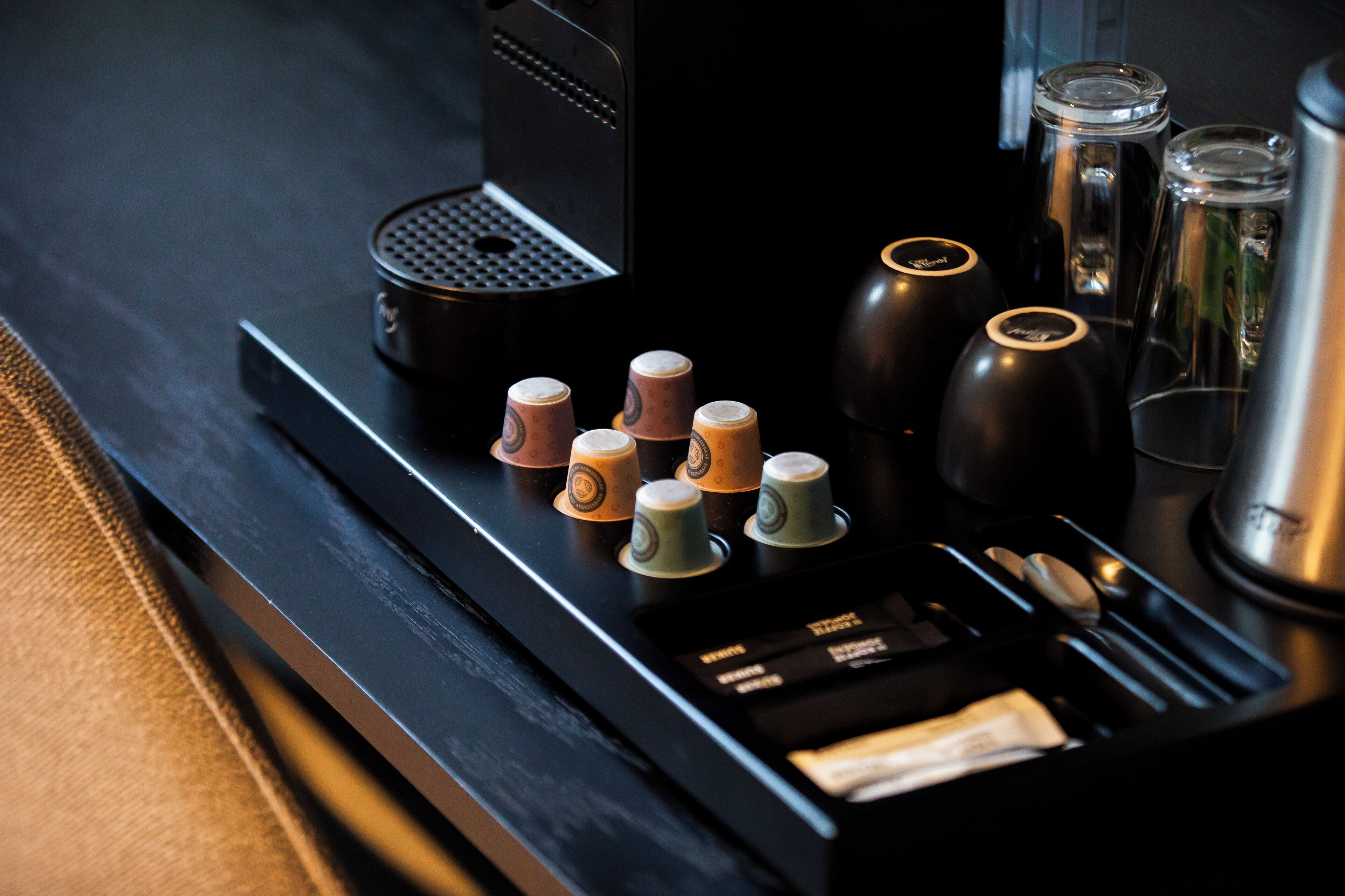 A coffee machine with multiple coffee cups and a milk frother.