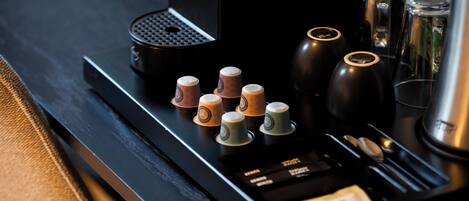 A coffee machine with multiple coffee cups and a milk frother.