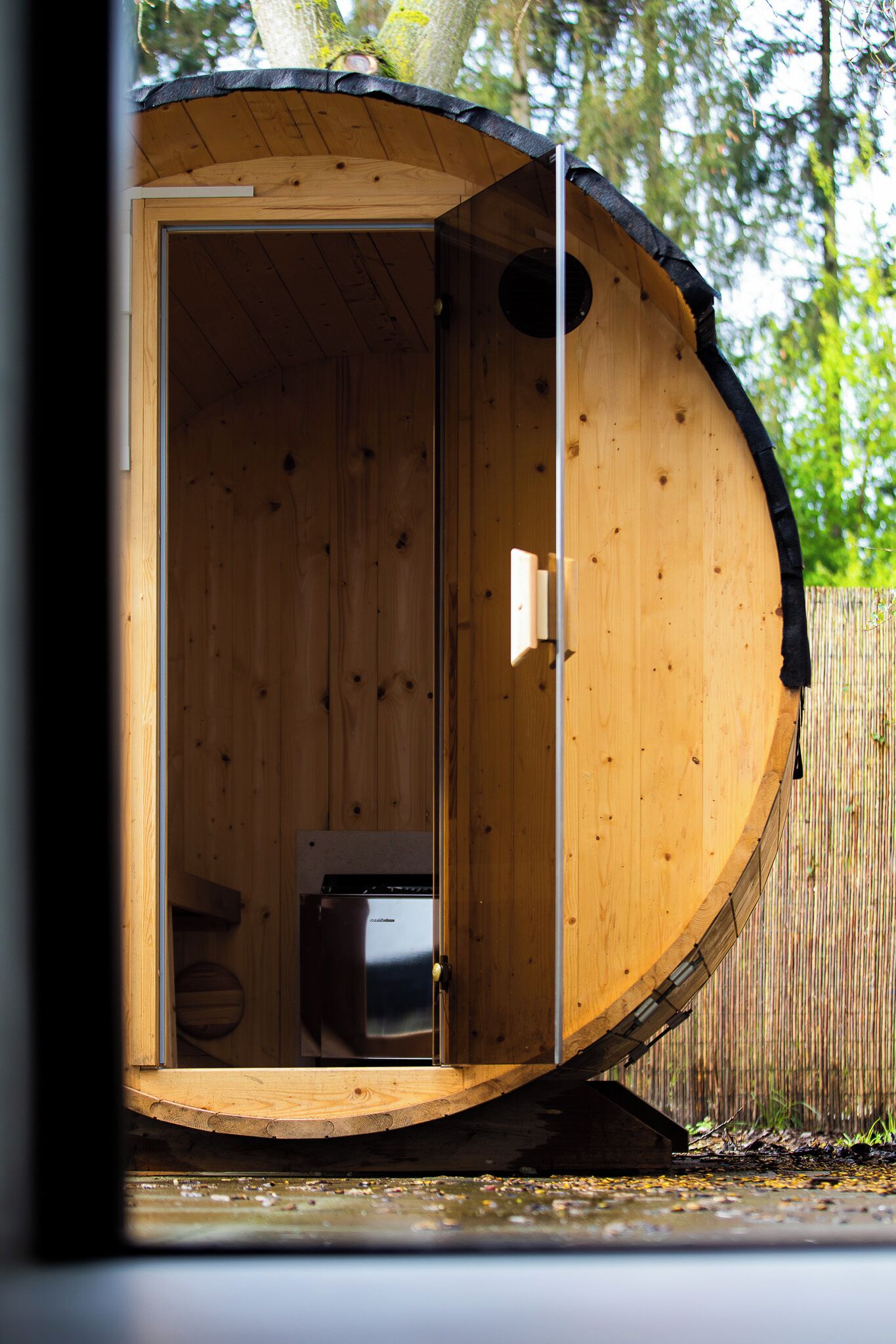 Une cabane en bois avec une seule porte, une petite fenêtre et un banc intégré.