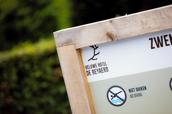 A sign with a no diving symbol and text indicating 'ZWEEN VELUWHE HOTEL DE BEYAERD'. - Veluwe Hotel de Beyaerd (Hulshorst)
