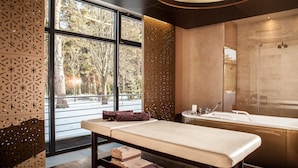 A modern bathroom with a large window, a bathtub, and a massage table. - Mercure Palanga Vanagupe Resort (Palanga)