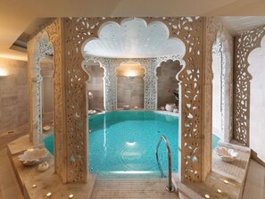 A luxurious indoor pool with intricate wooden carvings, a clear blue pool, and a modern design. - Mercure Palanga Vanagupe Resort (Palanga)