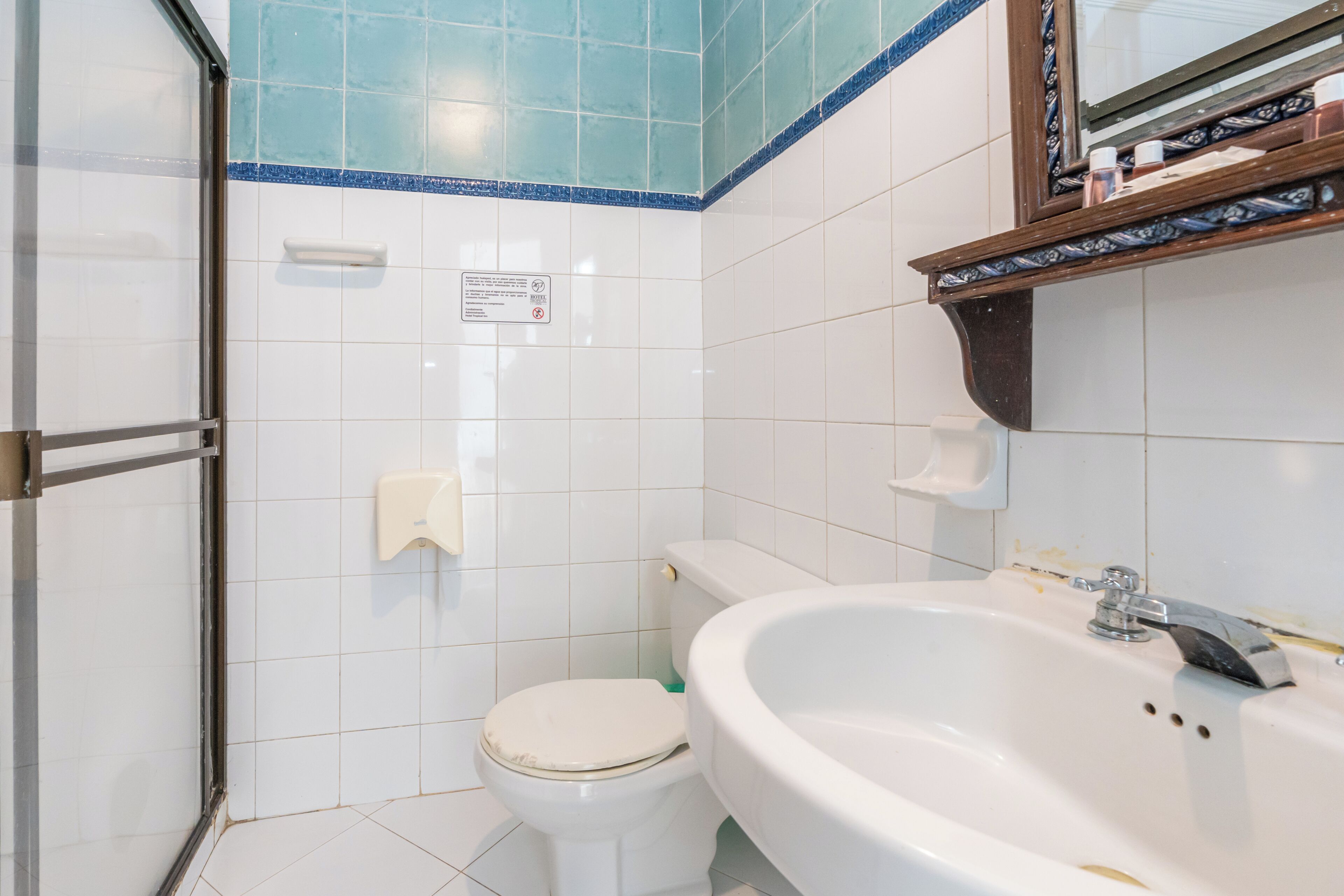 Un baño con inodoro, lavamanos y zona de ducha.