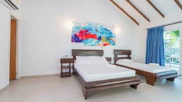 A room with two wooden beds, a large abstract painting, and a window with blue curtains.