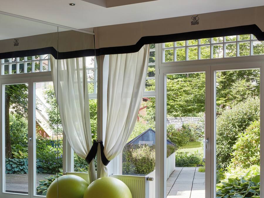 A spacious room with large windows, exercise balls, and yoga mats.