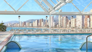 Una piscina cubierta, tumbonas