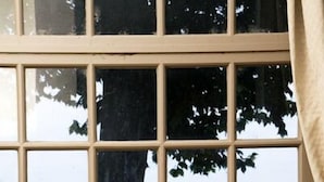 Mesa posta com itens de café da manhã, castiçal e vista para um rio com uma ponte.