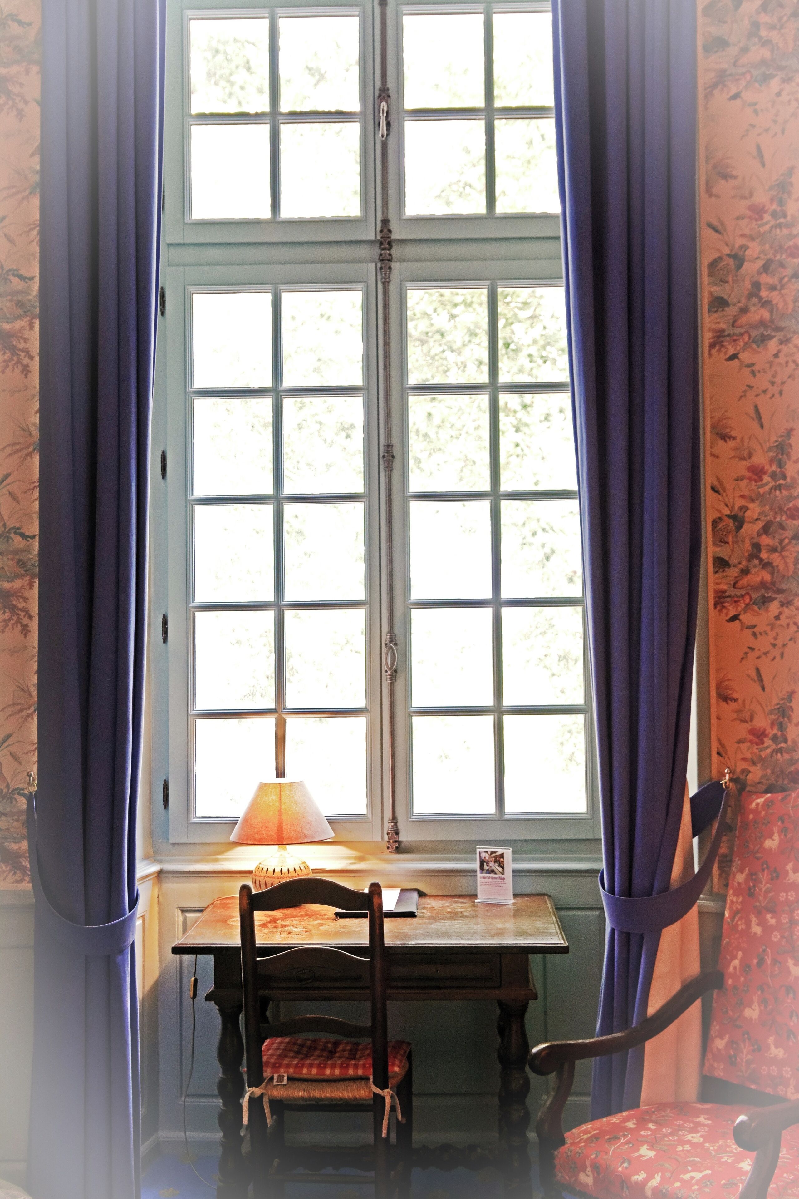 A room with a window, a table, and two chairs.