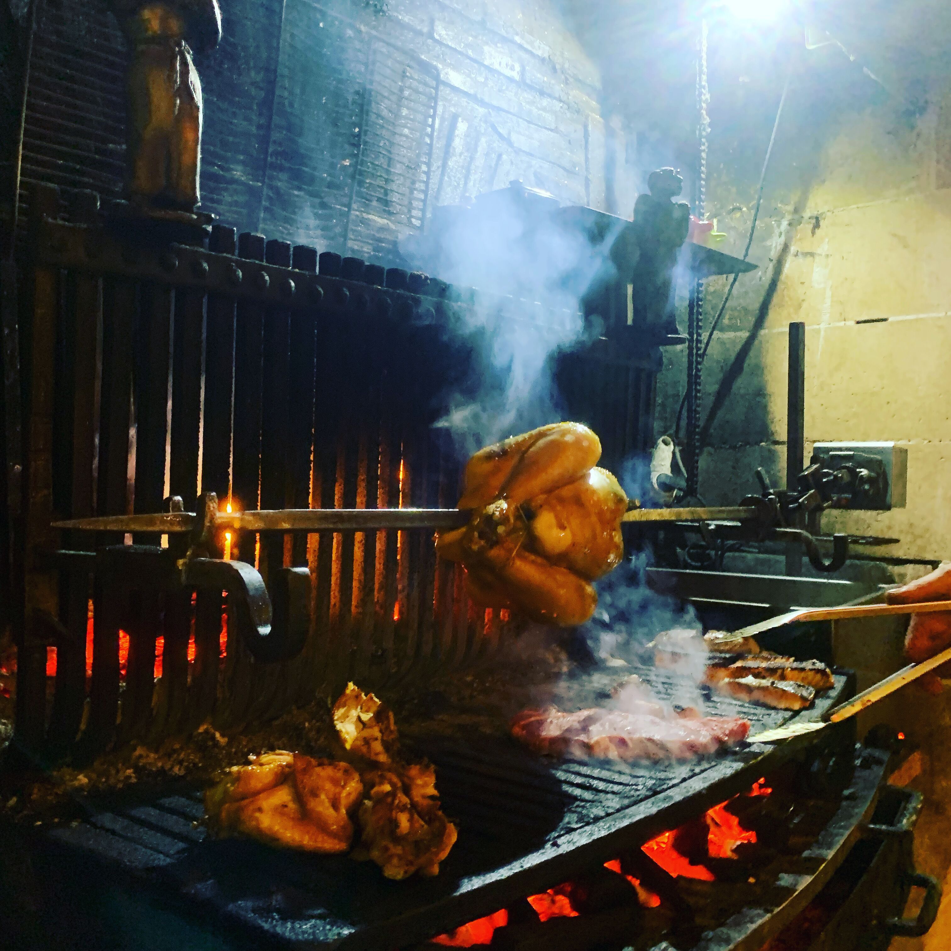 A grill with meat being cooked over an open flame.