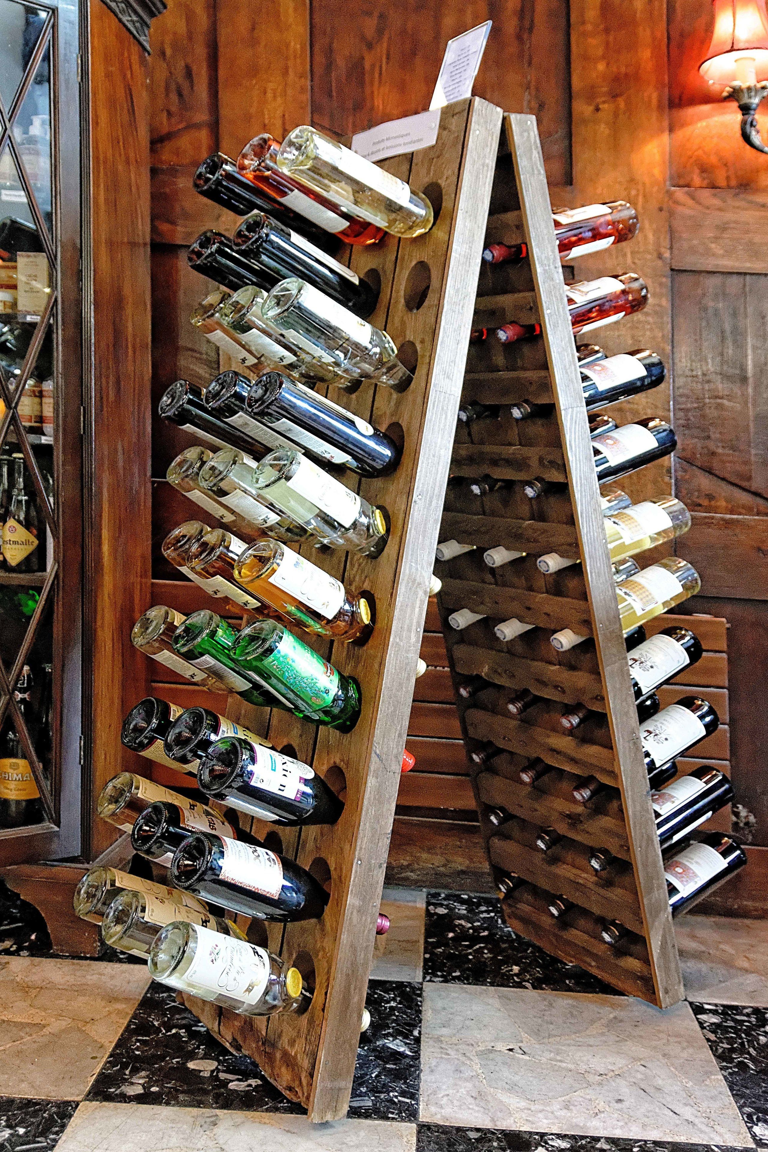 Una botellera de madera con varias botellas dispuestas vertical y horizontalmente.