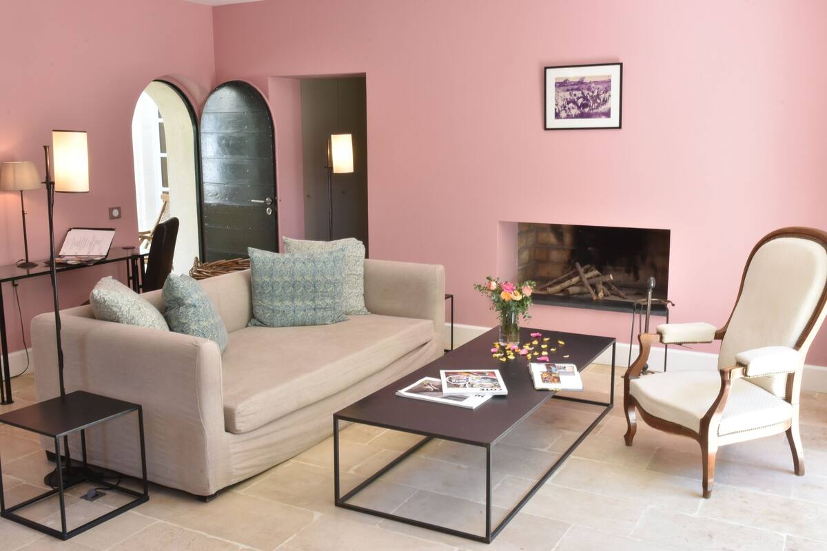 A living room with a beige sofa, a wooden chair, a coffee table, and a fireplace.