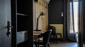 Habitació amb escriptori, cadira, làmpada i radiador.