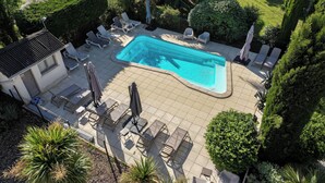 An aerial view of a backyard with a swimming pool, lounge chairs, and a patio area. - Hôtel Parc Adélie (Montagny-les-Beaune)