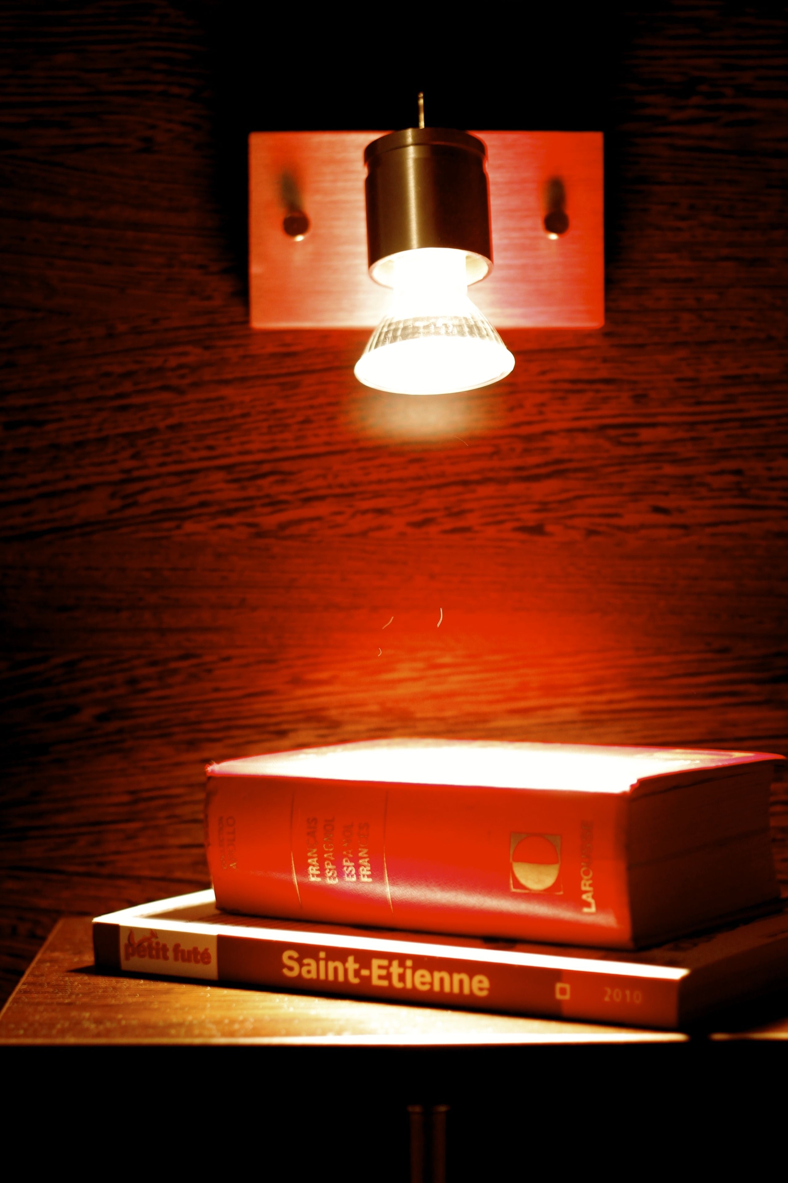 Una pila de libros con una lámpara colgando encima.