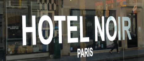 Una ventana con el texto "HOTEL NOIR PARIS" que indica el nombre del establecimiento.