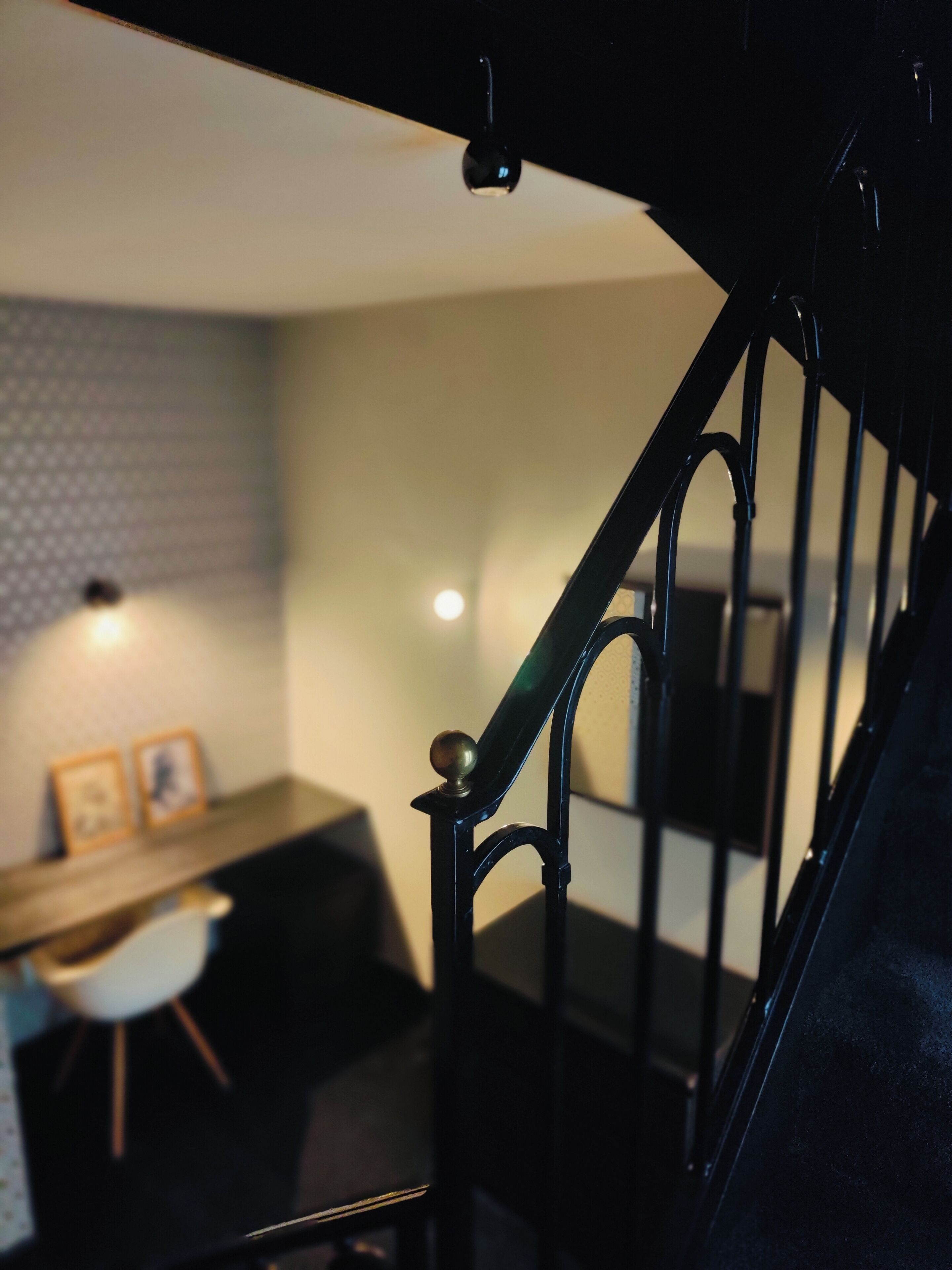 Een trap met een zwarte leuning en een houten balustrade.