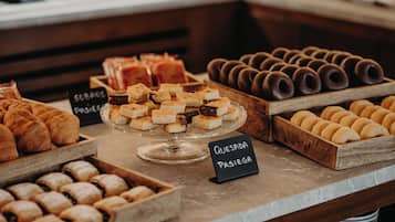 A bakery display with various pastries and baked goods, including a sign for queso pasiego.