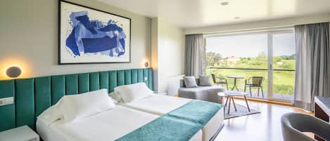 Una habitación de hotel con una cama grande, un escritorio y vistas al exterior.