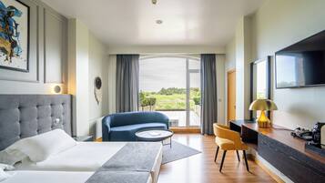 Een moderne hotelkamer met een groot bed, een bank, een bureau en een televisie.