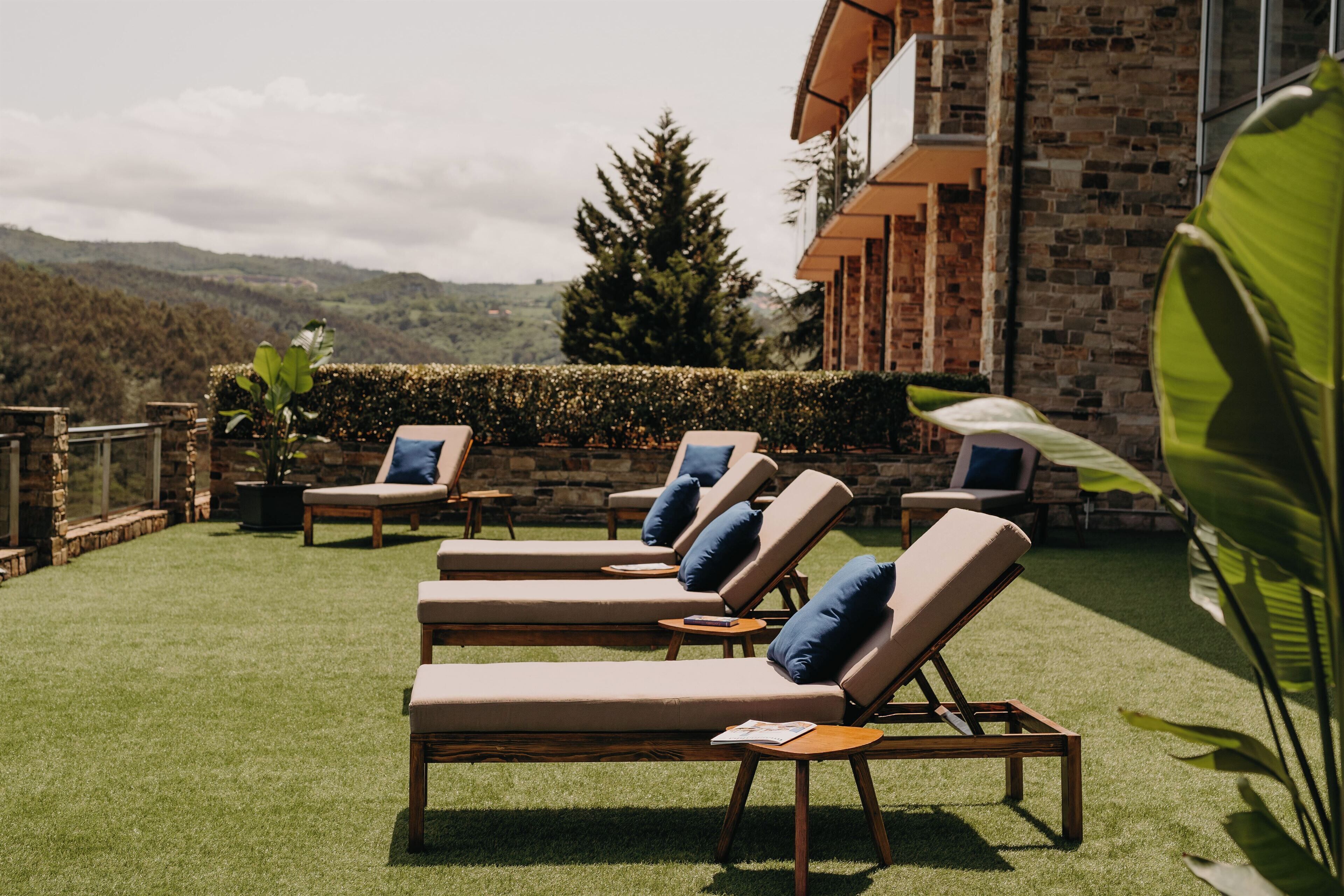 Une terrasse dotée de chaises longues et offrant une vue sur un paysage montagneux.